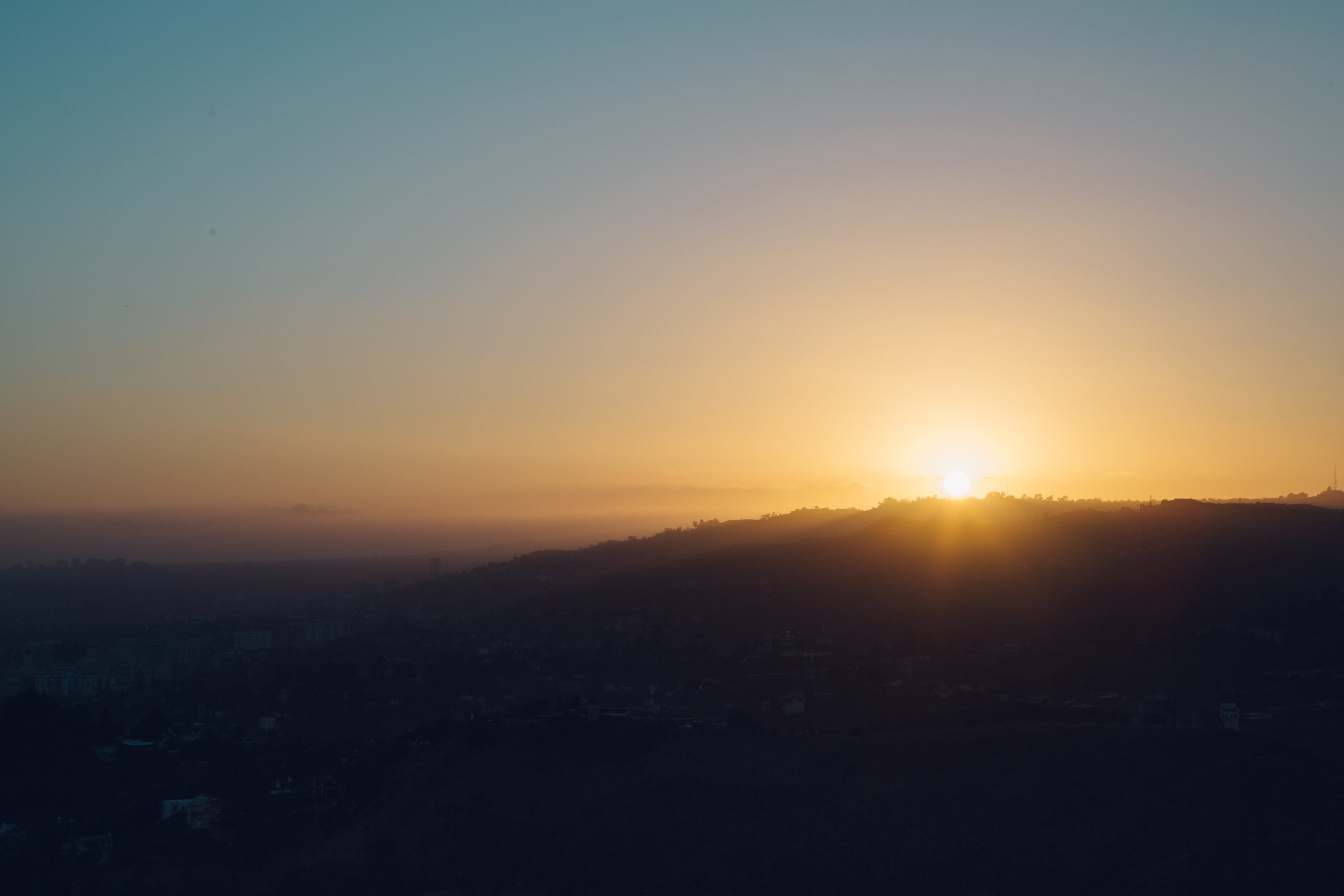Sunrise over hills representing circadian alignment and the primary principle of light and rhythm — Auralis Longevity